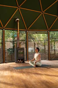 オリャンタイタンボにあるLas Qolqas EcoResort Ollantaytamboの暖炉前に腰掛けた女性