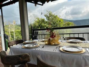 a table with a white table cloth and plates on it at Acaima Café Lodge in Sasaima