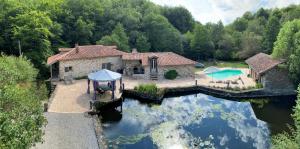 an aerial view of a house on the water at Moulin de Longuecoste, 11 couchages, Nature, Rivière, Piscine et Pool House in Montet-et-Bouxal