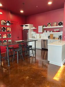 a kitchen with red walls and a table and chairs at Nashville Elvis Suite 4BR by Maddox Hotel in Nashville