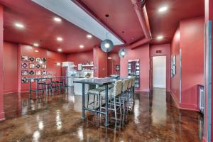 a kitchen with red walls and a bar with stools at Nashville Elvis Suite 4BR by Maddox Hotel in Nashville