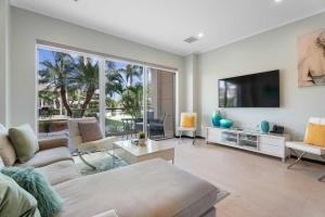 a living room with a couch and a flat screen tv at Eagle Beach - Pearl Garden 2BR condo - LV103 in Palm-Eagle Beach