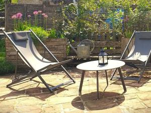 two lawn chairs and a table in a yard at Charmante maisonnette en pierre près d'Épinal - FR-1-589-804 in Uzemain +7 photos