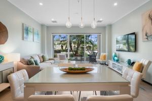 a dining room with a table and a living room at Eagle Beach - Pearl Garden 2BR condo - LV103 in Palm-Eagle Beach