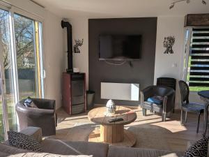 BertrichampsにあるGîte paisible avec parking, vue Vosges - FR-1-584-379のソファ、テレビ、テーブルのあるリビングルーム