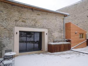a door to a brick building with snow on the ground at Espace de détente à Colombey avec SPA et jacuzzi - FR-1-611-115 in Colombey-les-deux-Églises