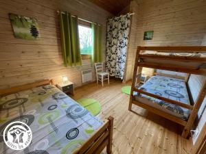 a bedroom with a bunk bed in a log cabin at Charmante maison en bois pour 5 personnes avec terrasse et jardin - FR-1-426-580 in Réaumur