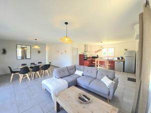 a living room with a couch and a table at Maison périgourdine avec piscine privative, internet et animaux acceptés - FR-1-616-476 in Sainte-Sabine