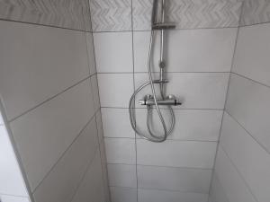 a shower with a hose in a white tiled bathroom at Maison de campagne paisible avec vaste espace extérieur - FR-1-589-808 in Uzemain +11 photos