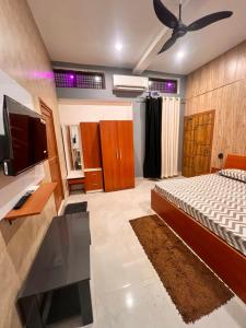 a bedroom with a bed and a flat screen tv at Shri Shyam Kunj in Ayodhya