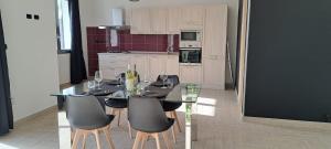 una sala da pranzo con tavolo e sedie in vetro di Casa Vacanza Martano a Martano