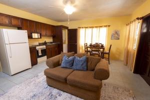 a living room with a couch and a kitchen at Cozy Coconut in East End Village