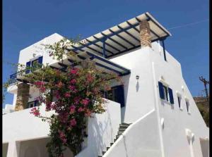 a white building with flowers on the side of it at Marina 3 in Agios Ioannis