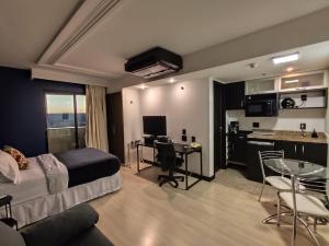 a bedroom with a bed and a desk and a kitchen at Lets Idea Brasilia Hotel - Flat Particular in Brasilia