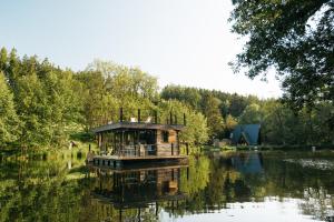 a house boat floating on a lake with trees at Živili in Smilkov