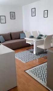 a living room with a couch and a table and chairs at Apartman Lopar 2,Crikvenica in Crikvenica