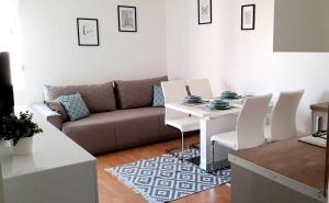 a living room with a couch and a table and chairs at Apartman Lopar 2,Crikvenica in Crikvenica
