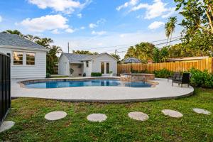 a backyard with a swimming pool and a fence at Poolside Getaway, Close To Dt Coastal Beach in West Palm Beach