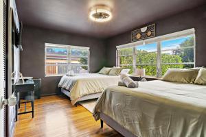 een slaapkamer met 2 bedden, een bureau en 2 ramen bij Game Room Pool Fun, Close To Downtown Life in West Palm Beach +35 foto's