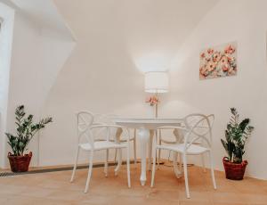 einen weißen Esstisch mit weißen Stühlen und einer Lampe in der Unterkunft Apartmán Baumgartner in Banská Štiavnica