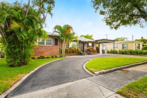 een huis met palmbomen en een oprit bij Game Room Pool Fun, Close To Downtown Life in West Palm Beach
