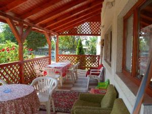 a patio with tables and chairs on a porch at Rózsakert Apartman 2 in Poroszló