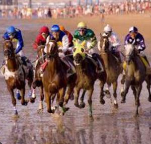a group of jockeys riding horses on a beach at Apartamento Relax Centro in Sanlúcar de Barrameda