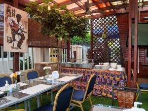 a restaurant with a table and chairs and a table at Asantewaa Premier Hotel in Kumasi