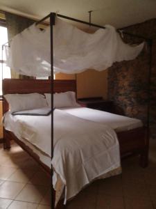 En eller flere senge i et værelse på Emanyatta Lodge