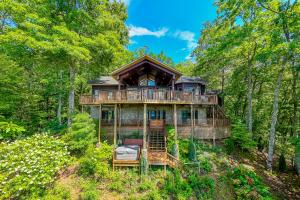a house in the woods with a wrap around deck at Majestic View cabin in Bryson City: 4BR, lake views, sleeps 10—your perfect mountain escape! in Bryson City