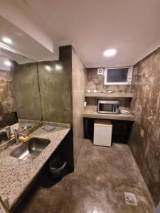 a small kitchen with a sink and a microwave at Santa Rosa Hotel in Olavarría +127 photos