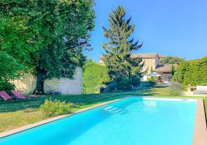 una piscina blu in un cortile con una casa di L'Envolée Sauvage a Cordes-sur-Ciel