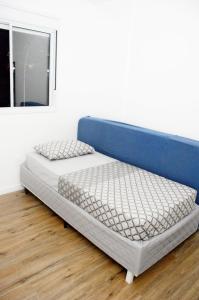 two beds in a room with a blue headboard at Apartamento aconchegante no bairro Liberdade in Sao Paulo