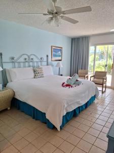 a bedroom with a large bed and a ceiling fan at Sibonne Beach Hotel in Grace Bay +52 photos