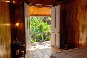 a bedroom with a door open to a porch with a view at Vạn Tùng Homestay & Café in Xuan An