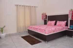 a bedroom with a large bed with pink sheets at Parmeshwari HOMESTAY in Jāmb