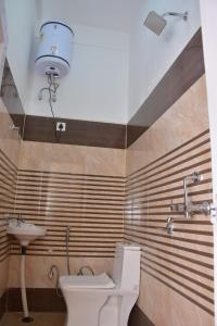 a bathroom with a toilet and a sink at Parmeshwari HOMESTAY in Jāmb