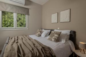 a bedroom with a large bed with two windows at Alavastros Villa Maisonettes in Vasilikos