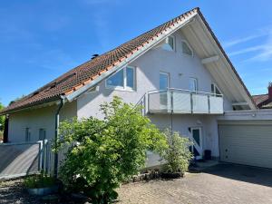 a white house with a balcony and a garage at Zieleckblick in Bad Sooden-Allendorf