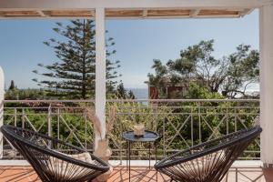 a patio with two chairs and a table on a balcony at Alavastros Villa Maisonettes in Vasilikos