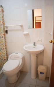 a white bathroom with a toilet and a sink at Hotel Everest in Pisac +53 photos
