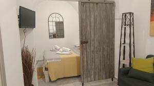 Una habitación con una cama y un televisor y una puerta de madera. en Casetta Anna Maria, en Fasano