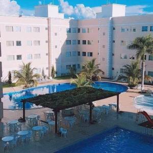 a large pool with tables and chairs in front of a building at Encontro das Águas Thermas Resort - Caldas Novas, Goiás in Caldas Novas +3 photos