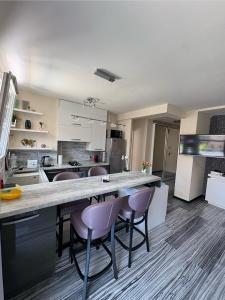 Una cocina con una gran encimera con sillas moradas. en Elegant Apartment Terrace Port of Nice, en Niza