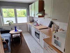 a kitchen with white cabinets and a small table at Ferienwohnung Silvia in Bleckede +5 photos