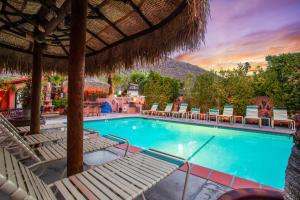 a swimming pool with lounge chairs and a resort at Coyote Inn - 21 and Over in Palm Springs