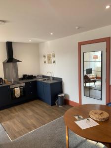 a kitchen with a table and a sink and a counter at Squirrel Away At Leven House in Crieff