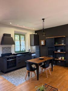 a kitchen with a wooden table and black appliances at CASA VASARI Holiday Suites TUSCANY in Lucignano