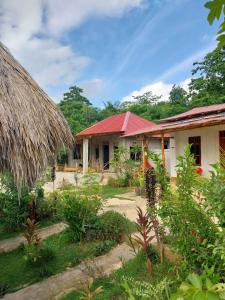 una casa con tetto di paglia e un cortile di See the sea eco Homestay a Patiala Bawa