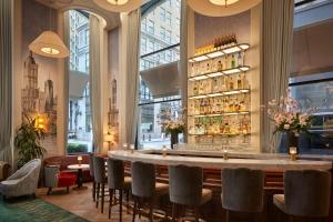 a bar in a restaurant with a large window at The Wall Street Hotel by Suiteness in New York